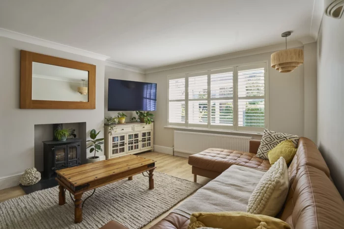 Salon lumineux au style naturel et chaleureux conçu par un architecte à Meudon, avec canapé en cuir et éléments bois
