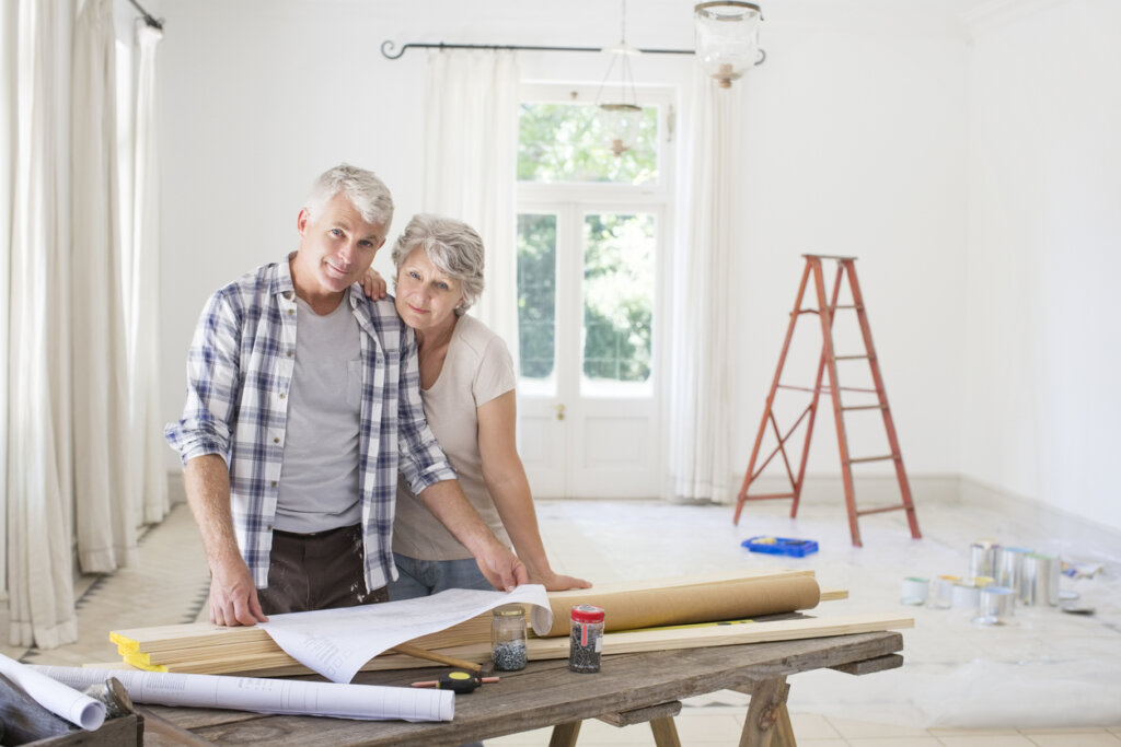 Couple âgé consultant des documents ensemble sur le coût pour rénover une maison