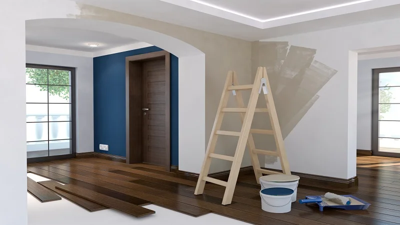 Intérieur d'une maison en rénovation, avec des travaux de peinture et de pose de parquet en cours, offrant un potentiel de personnalisation.