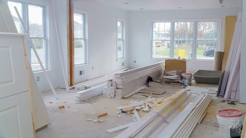 Une maison en cours de rénovation, avec des matériaux de construction et des équipements prêts à transformer l’espace en un lieu moderne et lumineux, située dans un cadre résidentiel.