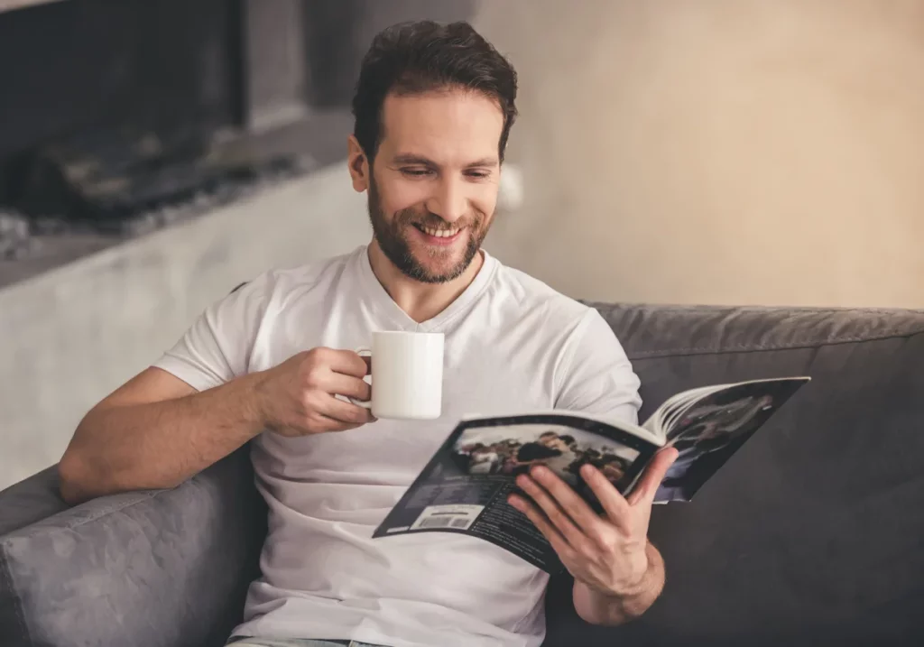 Un homme qui lit un magazine de décoration d'intérieur