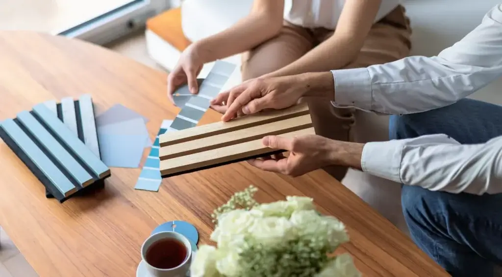 Le décorateur d'intérieur présente les matériaux et les couleurs à utiliser dans les intérieurs de la maison du client.