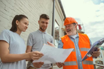 Un architecte qui montre le plan d'une maison à rénover à Challans