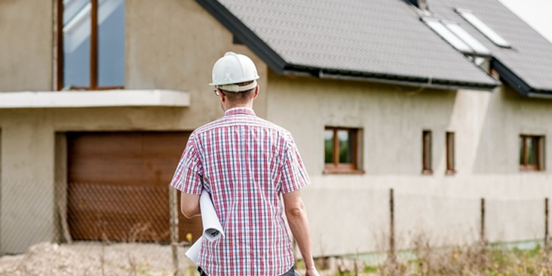 Professionnel avec un casque et des plans en main