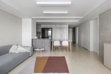 Appartement spacieux avec salon gris, cuisine ouverte et salle à manger, optimisé par un architecte à La Madeleine