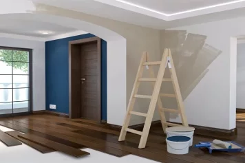 Intérieur d'une maison en rénovation, avec des travaux de peinture et de pose de parquet en cours, offrant un potentiel de personnalisation.