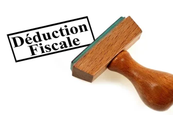 Mise en avant un tampon estampillé "Déduction Fiscale", symbolisant les avantages fiscaux potentiels liés à des projets tels que la rénovation immobilière ou les initiatives en faveur de l'efficacité énergétique.