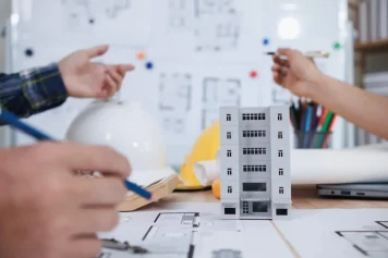 Vue sur un professionnel qui met au point le plan de rénovation immeuble de rapport.